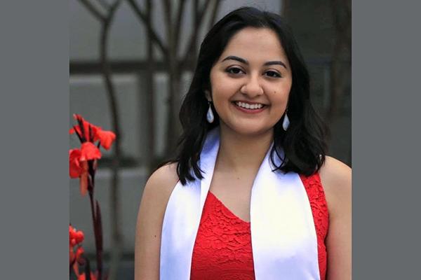 Post-Baccalaureate Program for Counseling and Psychology Professions graduate Karishma Bajaj outside in front of red flower