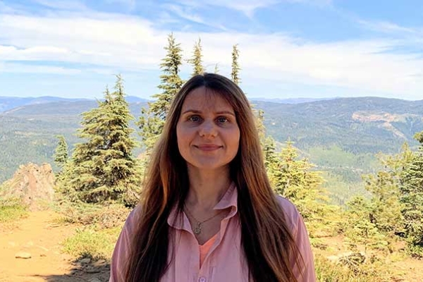 Photo of Tetiana Pairman in front of a forest and mountain background