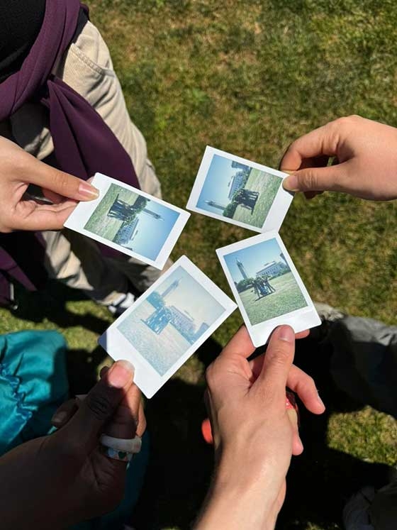 Mariane Iman Ndiaye and friends showing polaroid pictures