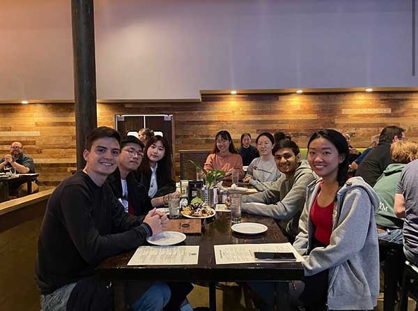 Xiangjian Zhang and friends sitting at a table waiting for food to arrive